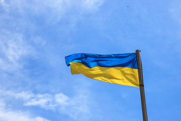 National flag of Ukraine flies in the blue sky. Yellow blue Ukrainian flag. Independence Day, Constitution, National Holiday
