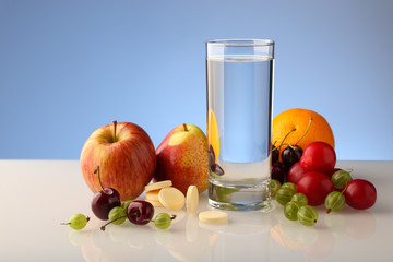 A glass of pure water with fruit and effervescent soluble vitamins in tablets.