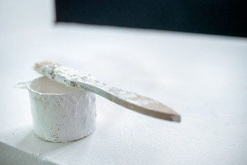brush in white paint. working brush in white paint lies on a can of paint. white paint with a brush on a white background