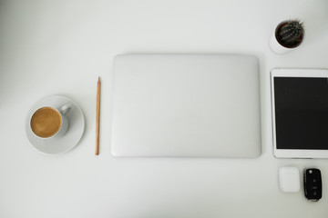 office table on which laptop, coffee, tablet, camera and other items