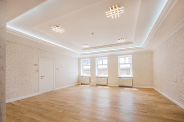 interior of the apartment or office room for receiving guests without furniture with wide windows and wooden floor, the interior is made in bright colors