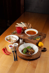 Set menu lunch in a restaurant: russian borscht, thai buckwheat noodles with vegetables and sesame, Caesar salad with croutons and chicken