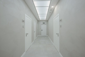 corridor in an office building with a large number of meeting rooms without furniture