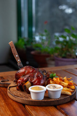Oktoberfest knuckle with baked crispy potatoes and classic german braised cabbage on a wooden table – ideal addition to beer