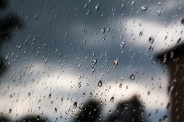 drops of rain on the window and cloudy sky on the background