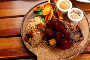 Unhealthy, but mouthwatering  pork knuckle with crispy fried potatoes and sweet braised cabbage in a classic german style