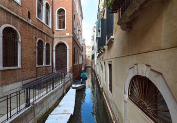 Fototapeta na wymiar Canal with covered boats in Venice