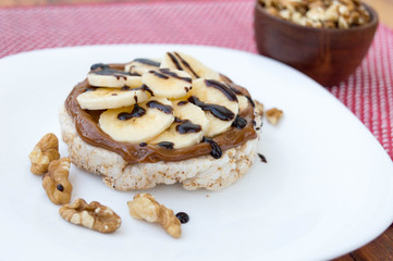 Rice biscuit with dulce de leche and pieces of banana and nuts. Accompanied with a milk banana smoothie. Added low calorie chocolate.