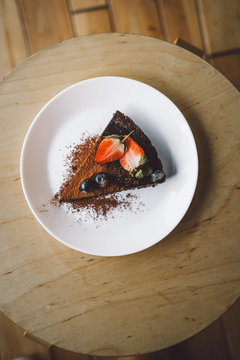 One slice of vegan raw chocolate  cake on wooden table from above. Sugar free, wheat free, dairy free, flourless dessert. Food photo, blog. Healthy eating, copyspace.