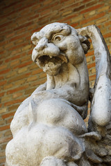 Fototapeta premium detail in foreground of an ancient gargoyle carved in stone