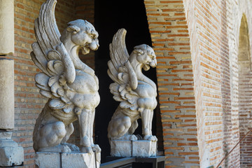 horizontal side view of two gargoyles carved in stone