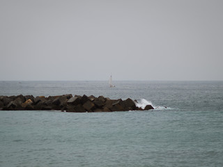 Small sail boat leaving the coast