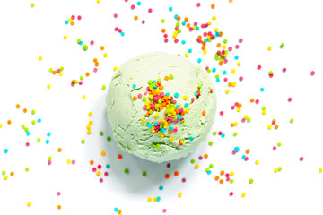 One ball of light green ice cream with colourful topping