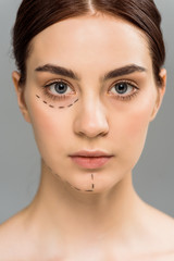 Obraz premium serious young woman with marks on face isolated on grey