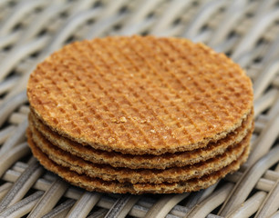 stack of traditional dutch stroopwafels cookie, a caramel syrup waffle, on wooden background