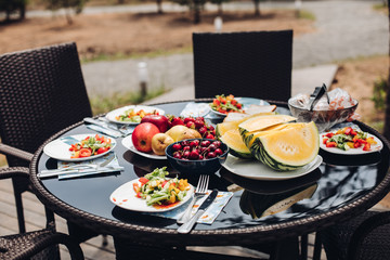 Delicious food from garden served on the table in backyard or terrace. Summer picnic concept. Salad served on the plates.