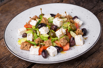 Greek salad on dark wooden