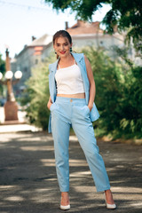 Gorgeous young model woman with perfect  hair looking at camera posing in the city wearing  classic costume.