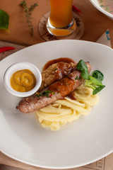 Traditional german sausage with mashed potato served with gravy and mustard