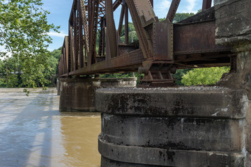 Old steel train bridge crossing over a calm river in a small midwestern town
