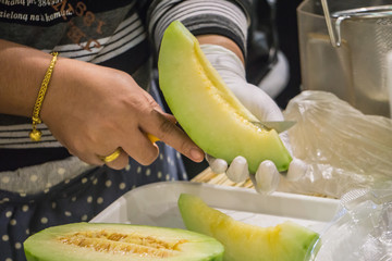 Female cutting Green Melon prepare to eat in Market Fresh Concept