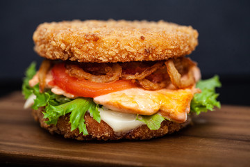 Sushi Burger with a variety of tasty ingredients on a dark background