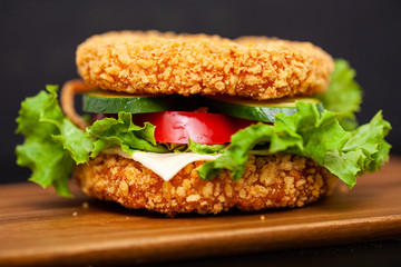Sushi Burger with a variety of tasty ingredients on a dark background