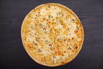 Tasty pizza with various flavored ingredients on a dark background