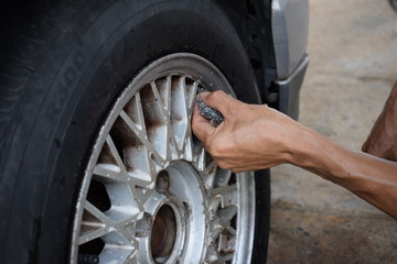 Men are washing old tires, dirty cars with bare hands.
