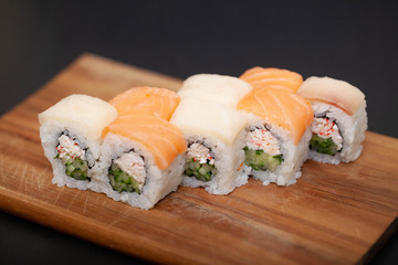 Sushi roll with salmon, cheese and avocado.