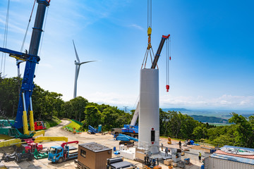 風力発電用風車の組み立て作業中と完成した風車