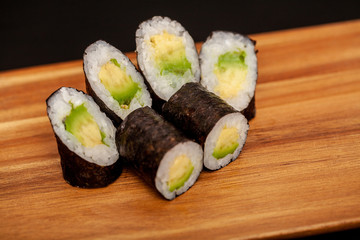 Japanese sushi maki rolls on dark background.