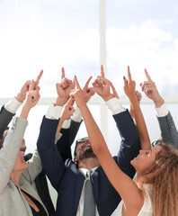 business team standing in a circle and pointing up