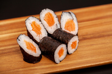 Japanese sushi maki rolls on dark background.