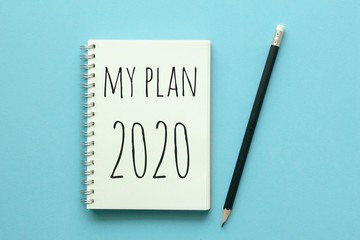 My plan 2020 on notebook with pencil on blue background.
