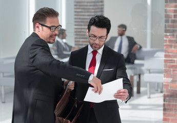 business men with documents in a large conference room