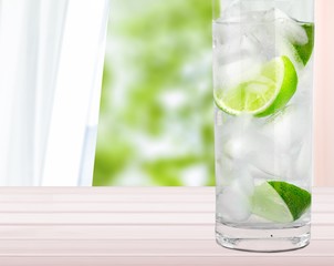 Glasses with fresh organic cucumber water on wooden table, on grey background