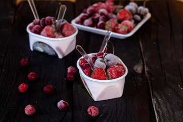 Homemade fresh yogurt. Healthy sweet dessert on dark rustic wood. Frozen fruits