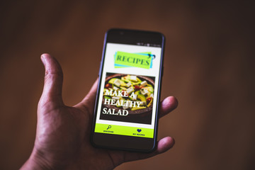 hand holding phone . online cooking blog . recipes channel