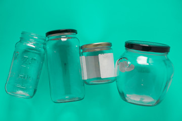 Isolated glass jars, flat and center on mint teal green background - recycling