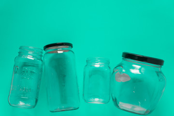 Isolated glass jars, flat and center on mint teal green background - recycling