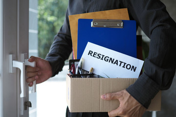 Businessmen hold boxes for personal belongings and resignation letters and open doors from the office. Including resignation from job positions and vacancies