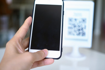 Hands use the phone to scan QR codes to receive discounts on purchases.
