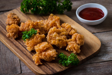 Crispy popcorn chicken on wooden board and dipping sauce