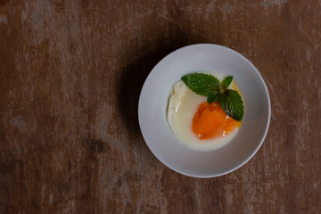 Soft-boiled egg in small white bowl on wooden table.
