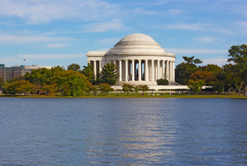 Thomas Jefferson Memorial in urban landscape of Washington DC in autumn, USA. Tidal Basin reservoir and city skyline on a sunny afternoon.