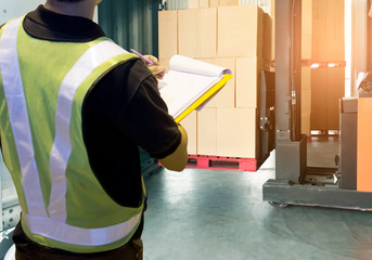 worker holding clipboard is checking and control forklift loading the shipment. © Siwakorn1933