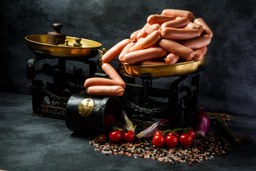 pile of uncooked long thin wieners on antiquarian scales