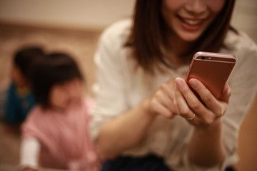 Fototapeta premium スマートフォンの操作に夢中になる母親
