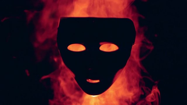 Human mask in the red fire